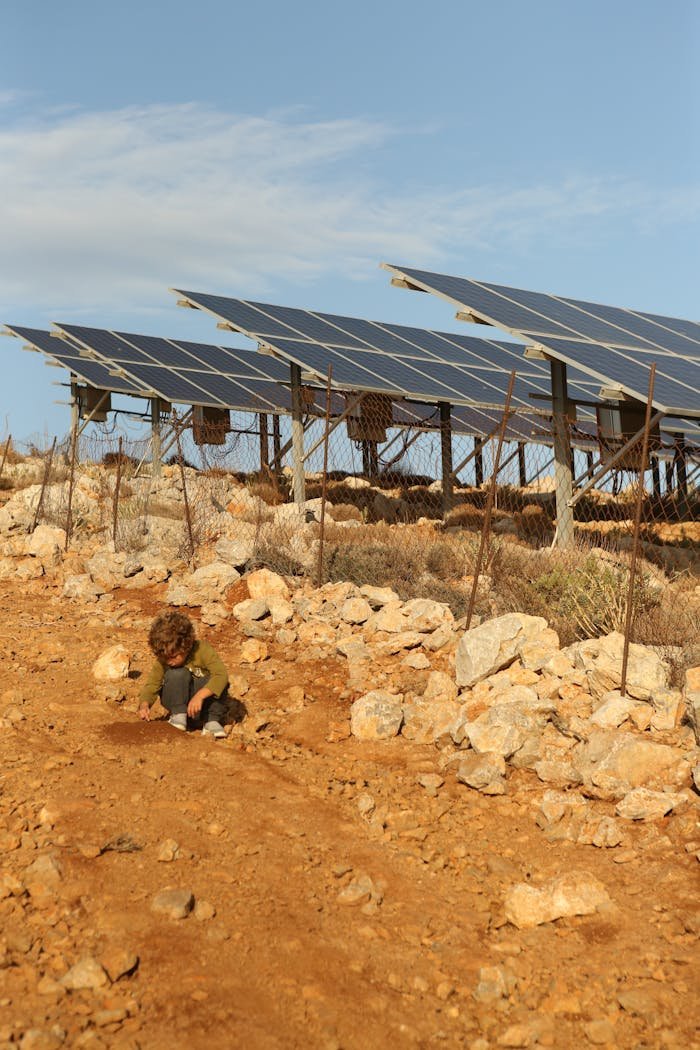 Child on Dirt Road near Solar Panels